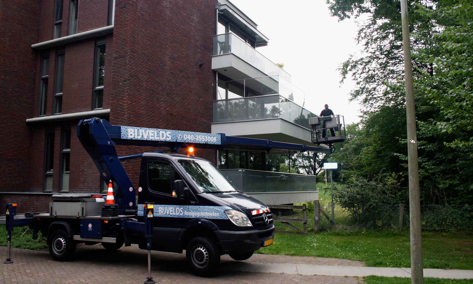 Glazenwasser in hoogwerker bij appartement in Oirschot